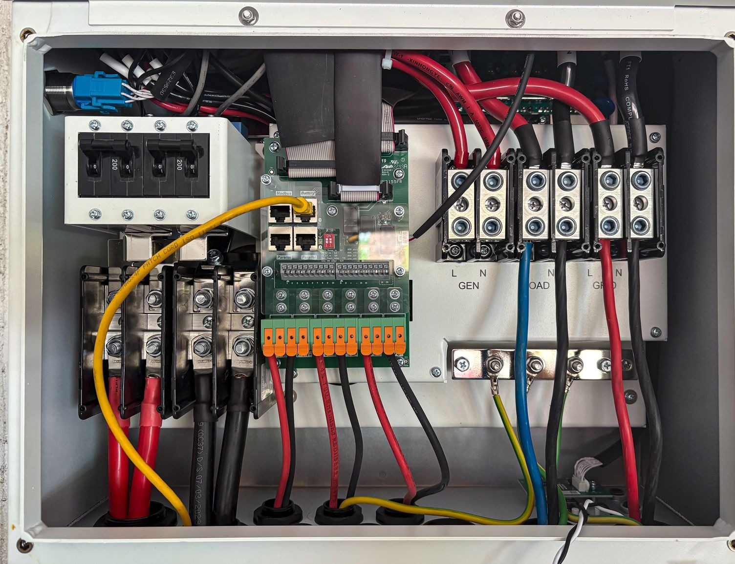 Bên trong tủ biến tần hybrid với cổng kết nối pin lưu trữ và các cọc đấu cáp