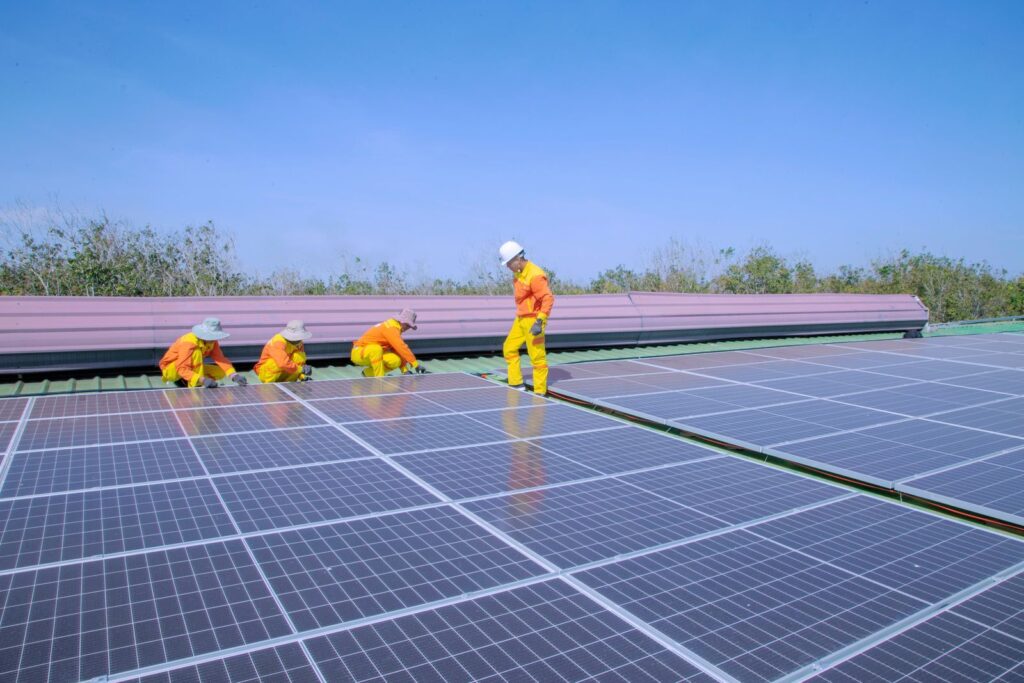 Đội thi công điện mặt trời làm việc trên mái nhà xưởng